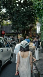 Asian Friends Walking on a Lush Tropical Street Mobile Wallpaper