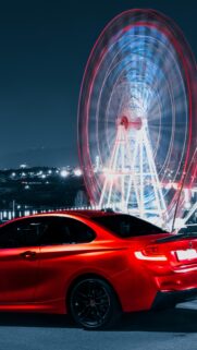 Red BMW Sports Car at Neon Carnival Night Mobile Wallpaper
