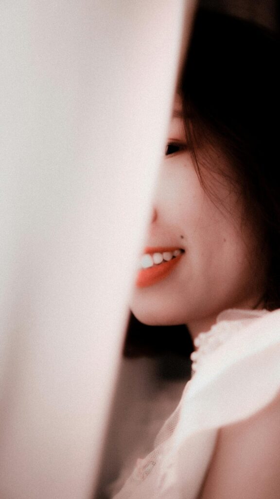 Beautiful Asian Girl Smiling Behind White Fabric Portrait Wallpaper