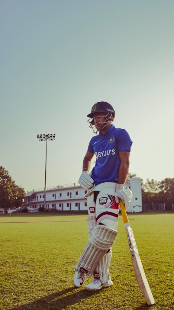 Young Cricket Player Standing on Field Mobile Wallpaper