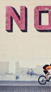 Urban Cyclist Riding Past Giant Wall Typography Minimalist Phone Wallpaper