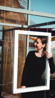 Smiling Woman Looking Through A White Frame Artistic Portrait Wallpaper