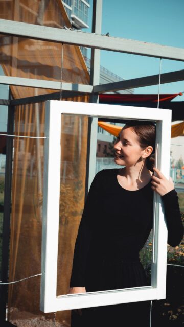 Smiling Woman Looking Through A White Frame Artistic Portrait Wallpaper