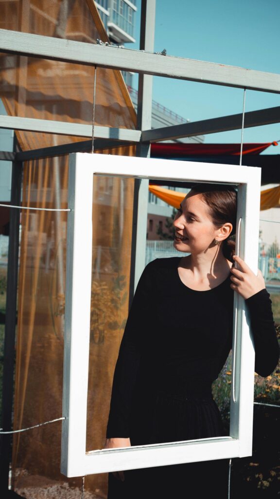 Smiling Woman Looking Through A White Frame Artistic Portrait Wallpaper