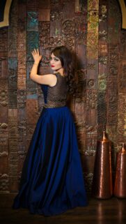 Elegant Woman in Royal Blue Gown against Carved Wood Wall Wallpaper