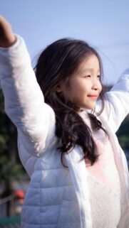 Happy Little Girl in White Jacket Outdoor Joy Phone Wallpaper