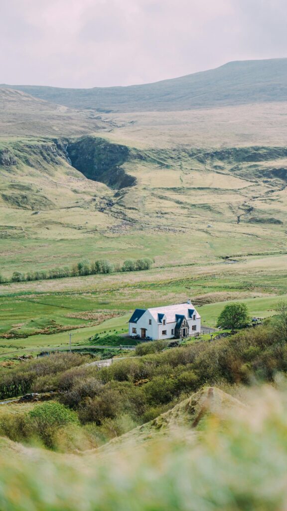 Picturesque Highland Cottage Nestled in Scottish Valley Wallpaper