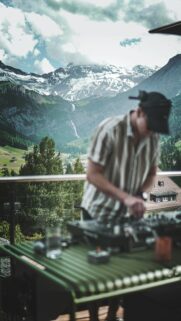 DJ Playing Music Overlooking Swiss Alps Scenic Mountain View Wallpaper