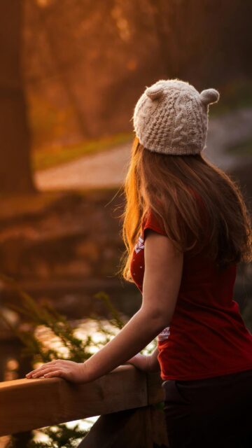 Girl in Bear Ear Beanie Hat Looking at Sunset Mobile Wallpaper