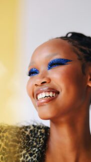 Stunning Close-Up Portrait of Woman with Vibrant Blue Glitter Eyeshadow Wallpaper