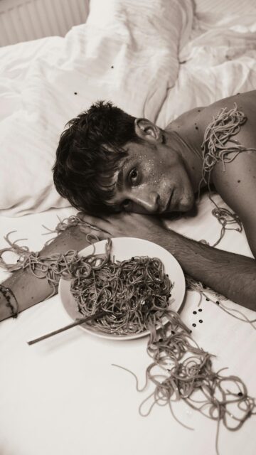 Young Man with Spaghetti and Glitter Surreal Artistic Phone Wallpaper