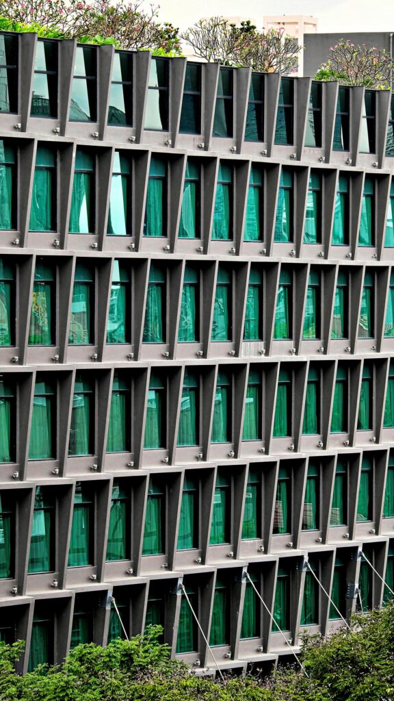 Modern Architectural Facade with Geometric Green Windows Wallpaper