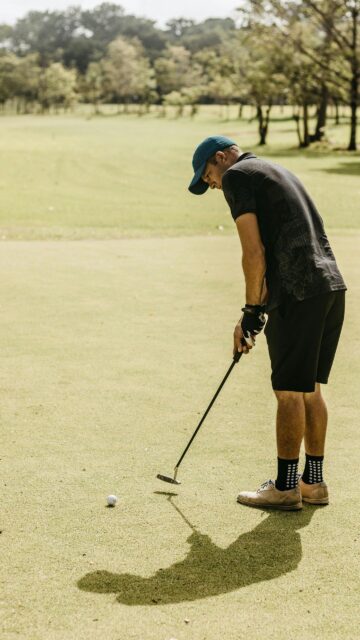 Professional Golfer Preparing for a Precision Putt Phone Wallpaper