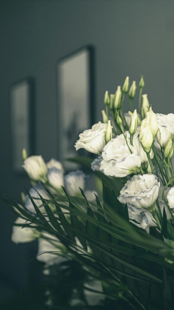 Elegant White Lisianthus Flowers with Green Palm Leaves Wallpaper
