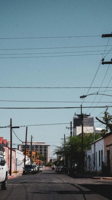 Urban Street Perspective Under Clear Blue Sky Phone Wallpaper