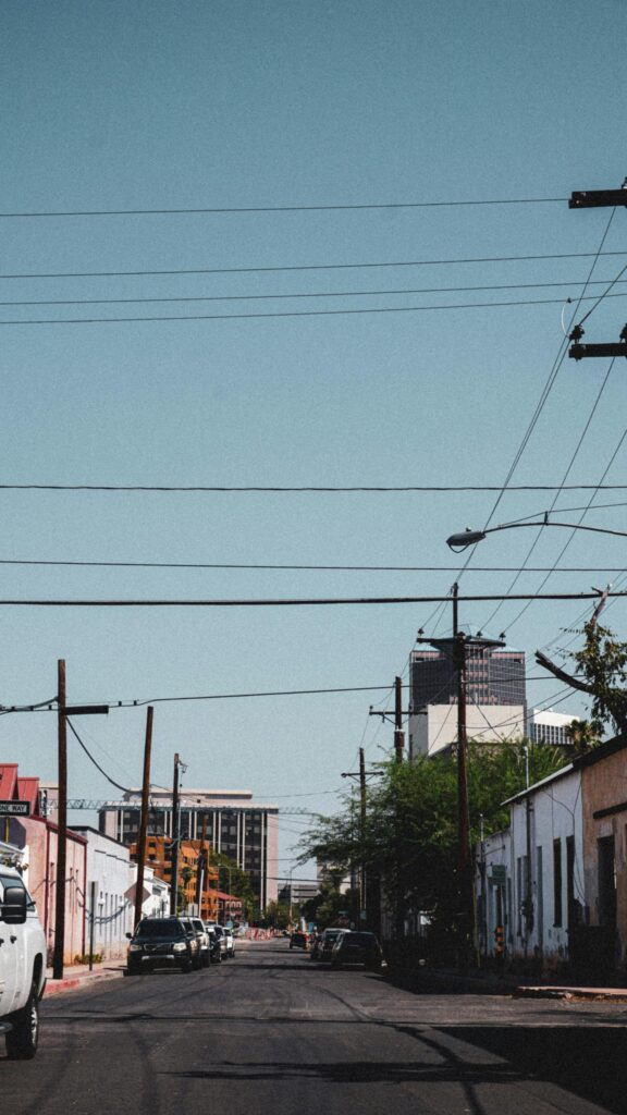 Urban Street Perspective Under Clear Blue Sky Phone Wallpaper