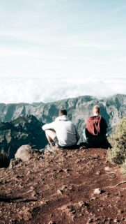 Two Friends Sitting on Mountain Peak Above Clouds Mobile Wallpaper