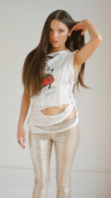 Olivia Rodrigo Stylish Mickey Mouse Tee and Sequin Pants High Resolution Wallpaper
