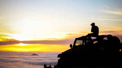 Silhouette Man on Off-Road Jeep Above Clouds Sunset 4K Wallpaper