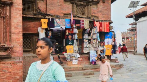 Asian Girls Walking Through Historical Nepali Marketplace 4K Wallpaper