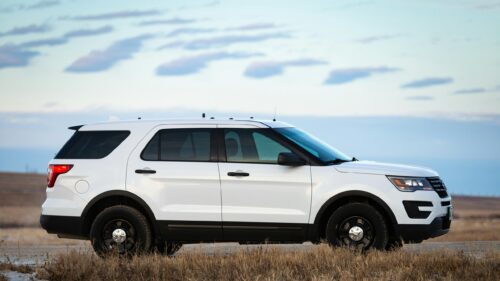 White Ford Police Interceptor SUV in Open Field 4K Wallpaper