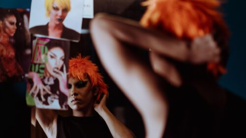 Drag Queen Preparing in Mirror Orange Wig Portrait Desktop Wallpaper