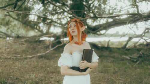 Fantasy Elf Girl Holding an Ancient Book in the Forest Desktop Wallpaper