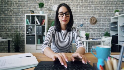 Professional Woman Working on Laptop in Modern Office Desktop Wallpaper
