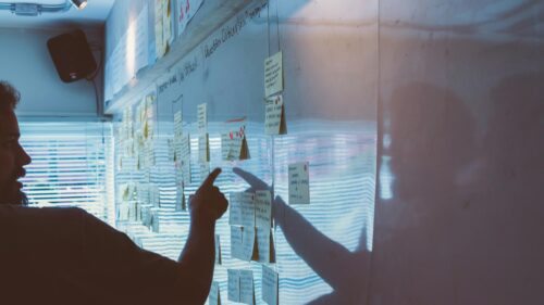 Man Analyzing Ideas on Office Whiteboard 4K Desktop Wallpaper