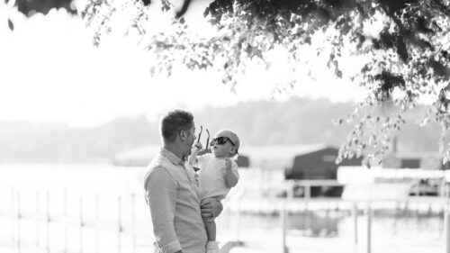 Father and Baby Wearing Sunglasses Under Sunlit Trees Desktop Wallpaper