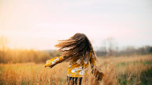 Girl Spinning in Golden Field with Flowing Hair 4K Desktop Wallpaper