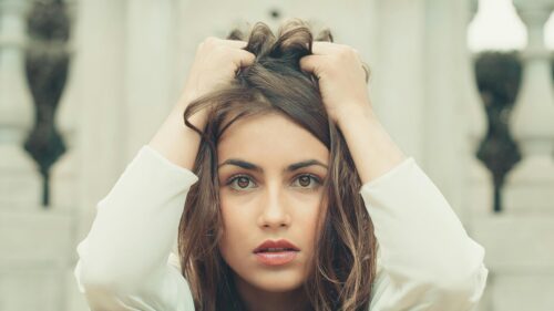 Stunning Portrait of a Young Woman Touching Her Hair Desktop Wallpaper