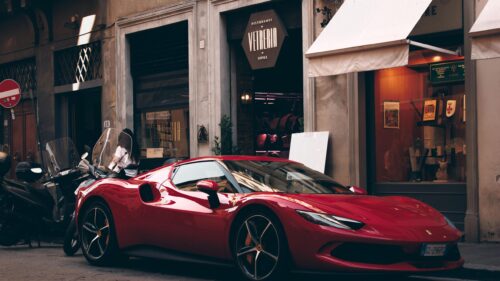 Red Ferrari Sports Car Parked on Historic Italian Street 4K Wallpaper
