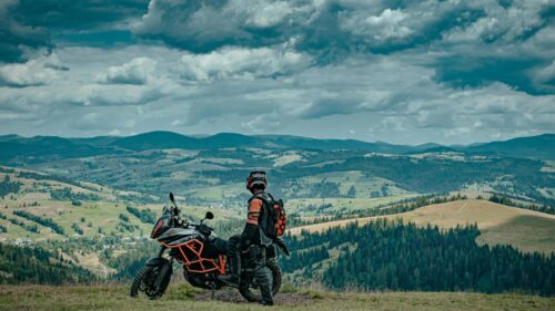 Adventurer Biker Overlooking Scenic Mountain Valley 4K Wallpaper