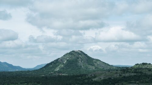 Majestic Green Mountain Peak Under Cloudy Sky 4K Wallpaper
