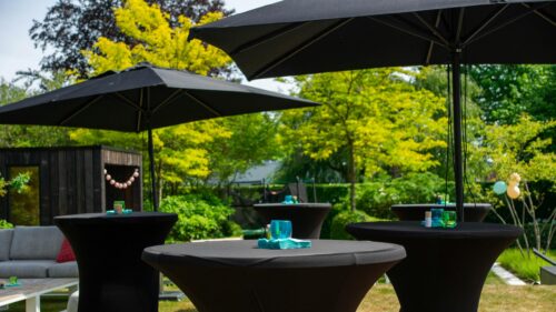 Elegant Garden Party Setup with Black Tables and Umbrellas 4K Wallpaper