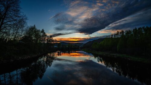 Stunning Sunset River Reflection Over Lush Forest Landscape 4K Wallpaper