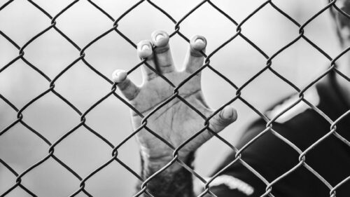 Dramatic Hand Gripping Chain Link Fence Black and White PC Wallpaper