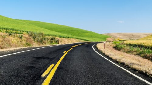 Scenic Winding Road Through Rolling Green Hills Landscape PC Wallpaper