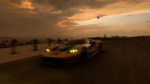 Yellow Ford GT Race Car Speeding at Sunset Desktop Wallpaper
