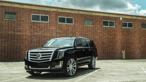 Black Cadillac Escalade Luxury SUV Parked Against Red Brick Wall PC Wallpaper