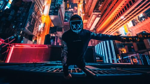 Neon Purge Mask Person in Cyberpunk City Night 4K Wallpaper