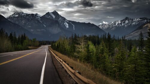 Dramatic Mountain Highway Road Trip Under Stormy Skies PC Wallpaper