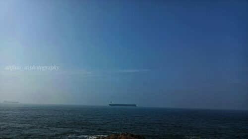 Vast Calm Ocean with Cargo Ship at Horizon 4K Desktop Wallpaper