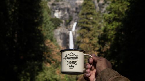 A Person Holding a Coffee Mug with Yosemite Waterfall Background 4K Wallpaper