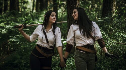 Two Female Warriors Holding Hands in Enchanted Forest Desktop Wallpaper