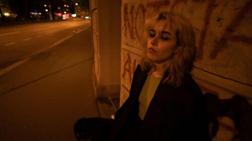 Melancholic Woman Leaning Against Urban Graffiti Wall 4K Desktop Wallpaper