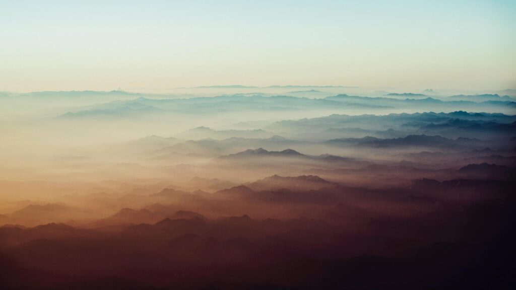 Breathtaking Aerial View of Mist Covered Mountain Ranges 4K Wallpaper