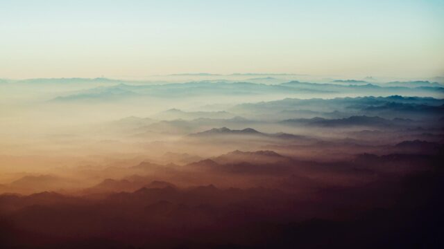 Breathtaking Aerial View of Mist Covered Mountain Ranges 4K Wallpaper