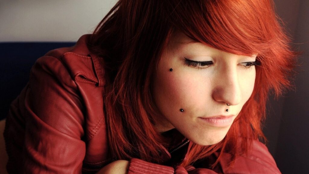 Stunning Young Woman with Vibrant Red Hair and Piercings 4K Wallpaper